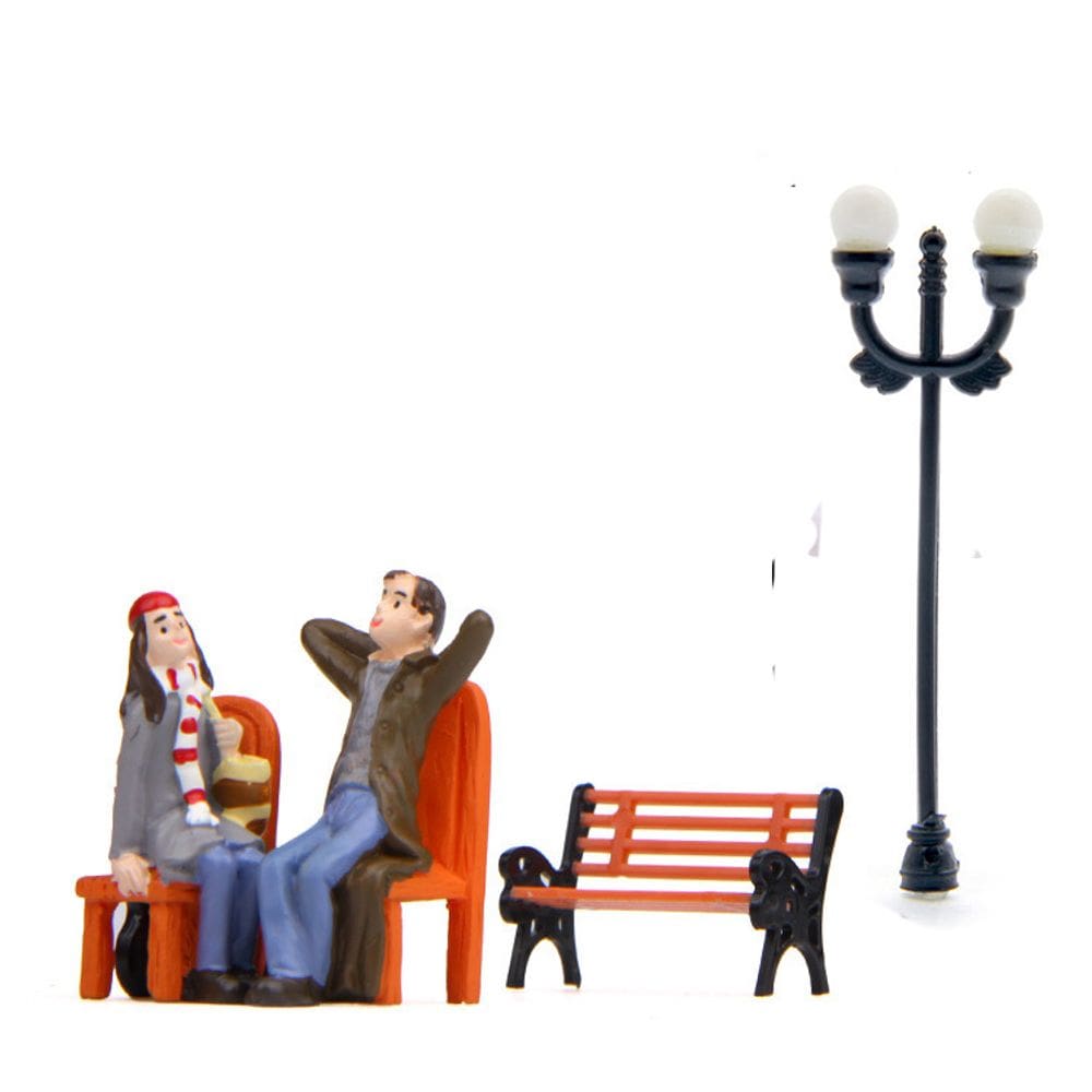 Casal de escultura em resina de jardim sentado no banco do parque com lâmpada